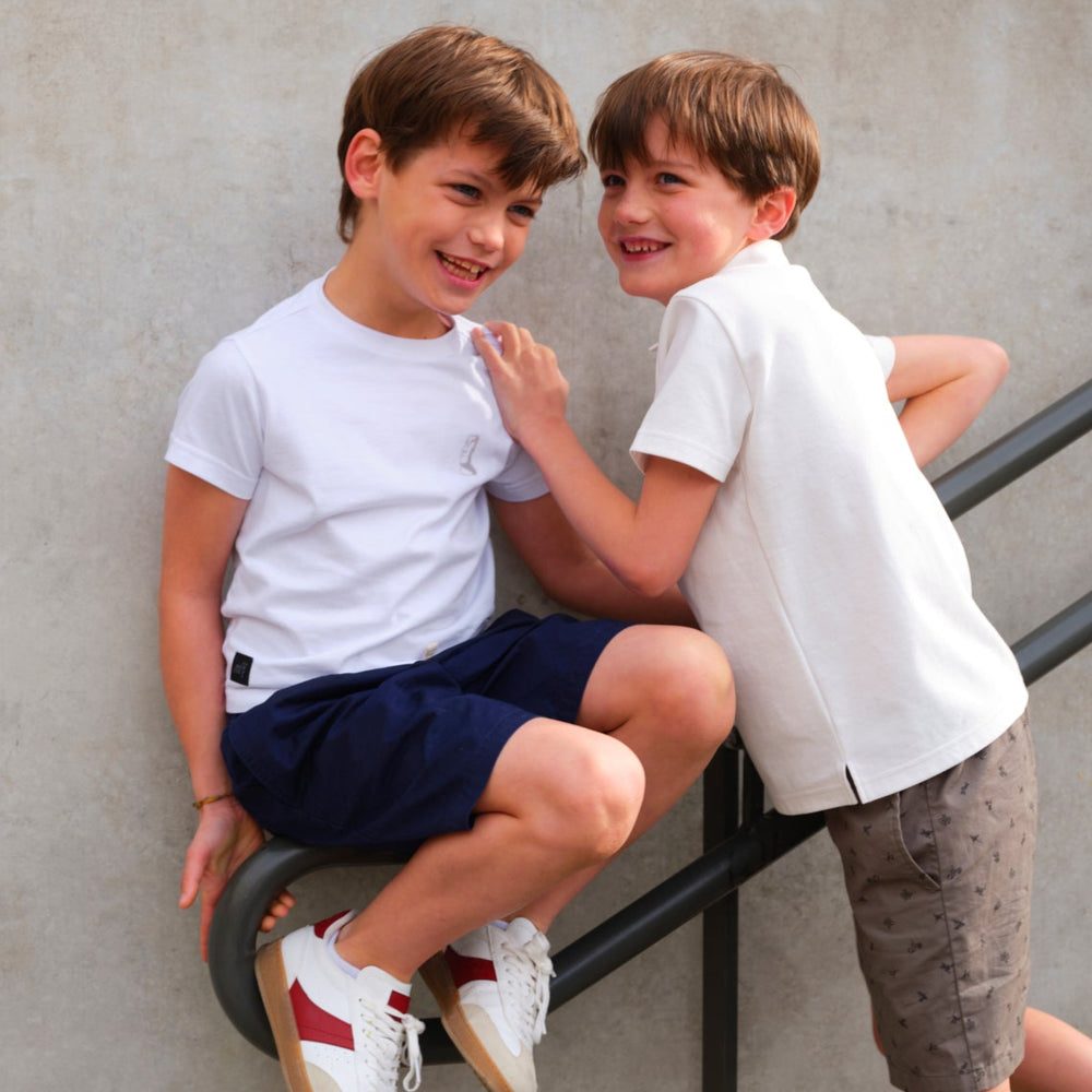 Two boys laughing together on a stair railing