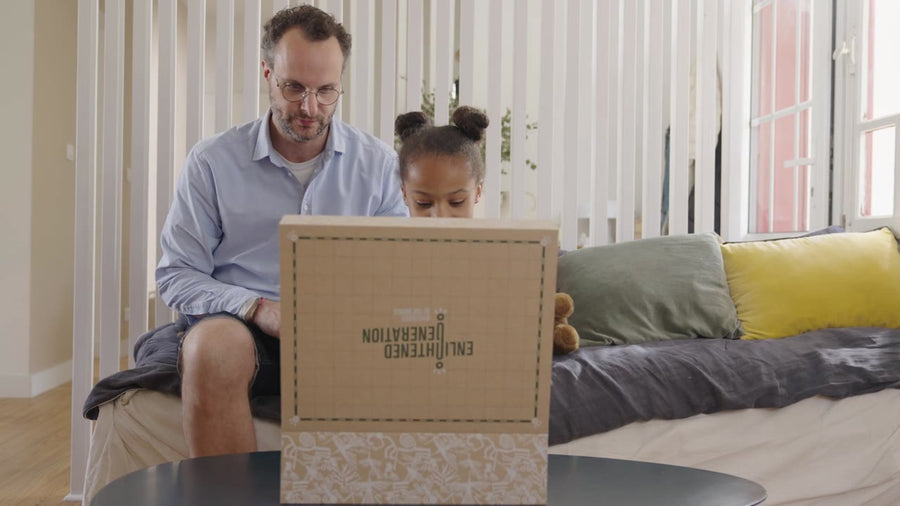 A dad and daughter with the keepsake box on the sofa